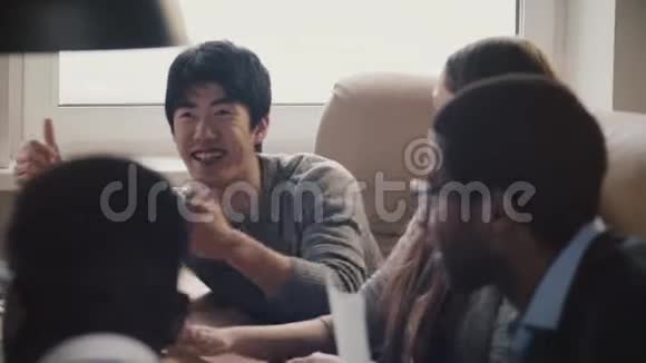 快乐自信的日本年轻自由商人分享想法微笑着在多民族办公室会议上慢动作视频的预览图