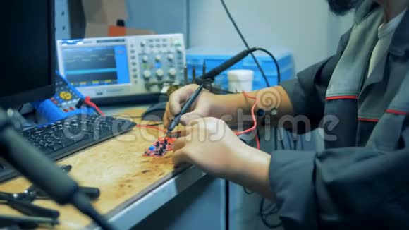 一个有双手假体的残疾人用电压表工作并关闭视频的预览图