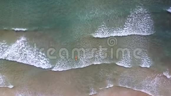 Flycam下降到女性在阳光下的海浪冲浪视频的预览图