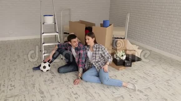 一对幸福的年轻夫妇在新公寓里带着足球的肖像视频的预览图