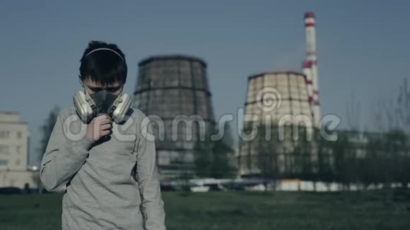 十几岁的年轻人戴着防毒面具对着工厂的烟囱这个男孩因为污染而窒息他咳嗽视频的预览图