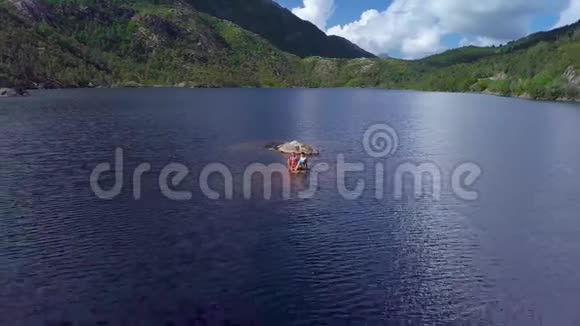 少女在山湖游泳的鸟瞰图视频的预览图