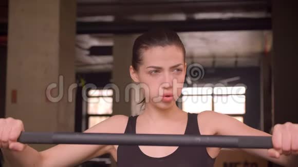 年轻有魅力的运动员的特写镜头女性在健身房里坚定地行走和准备举重视频的预览图