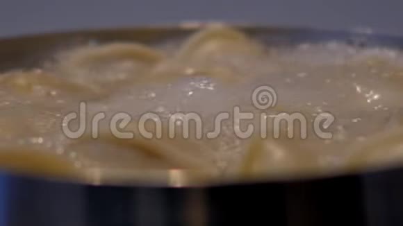 黄水饺在汩汩的水中用泡沫煮沸视频的预览图