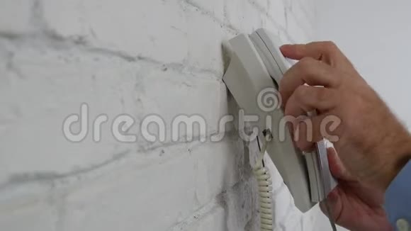 办公室附近的商人在墙上拨一个号码试着打个电话视频的预览图