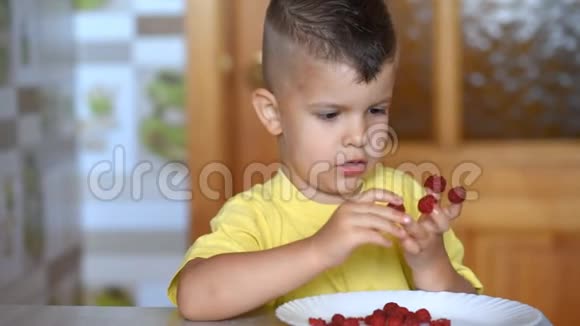 孩子坐在桌边在厨房吃树莓视频的预览图