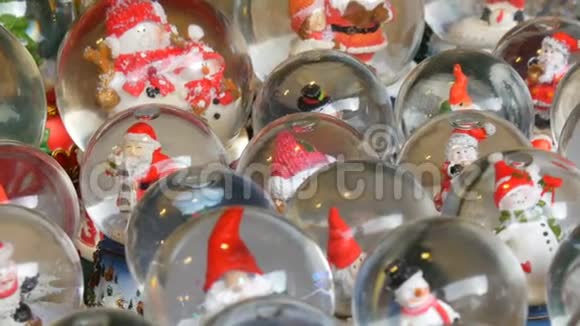 很多带有圣诞老人的装饰雪球或圣诞球圣诞节和新年家庭装饰视频的预览图
