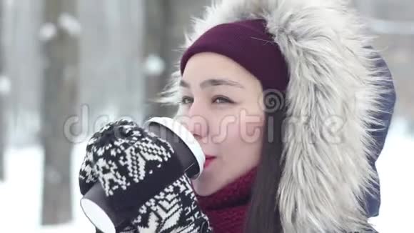 美丽的年轻女孩在雪地公园享受冬天的景色和喝咖啡视频的预览图