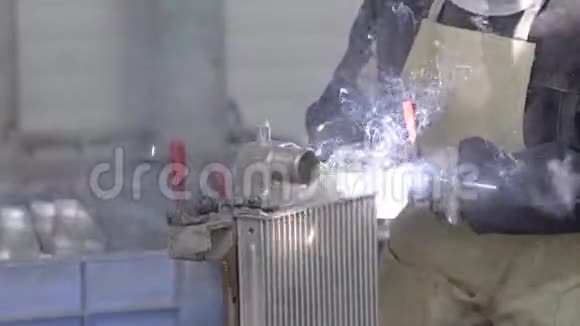特殊面罩的焊工在工业企业生产冷却散热器金属部件的焊接视频的预览图