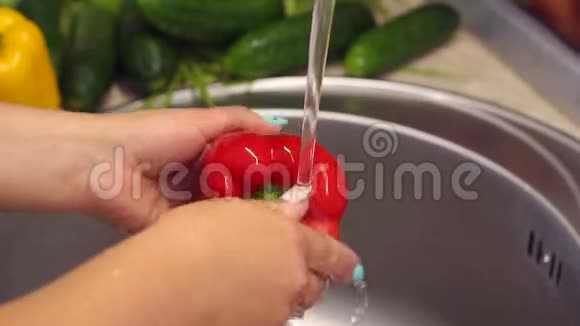 女人在厨房里洗红辣椒自制食品概念慢动作视频的预览图