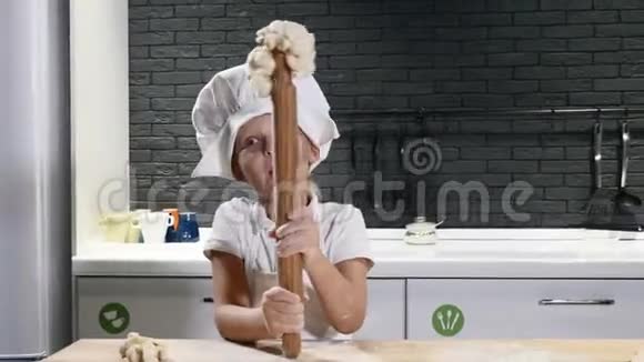 戴厨师帽的可爱小男孩拿着擀面杖玩得很开心有趣的烹饪理念4公里视频的预览图