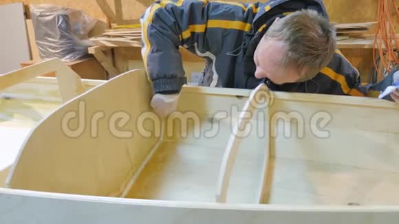 一个人收集一艘木头做的船他从事体力劳动视频的预览图