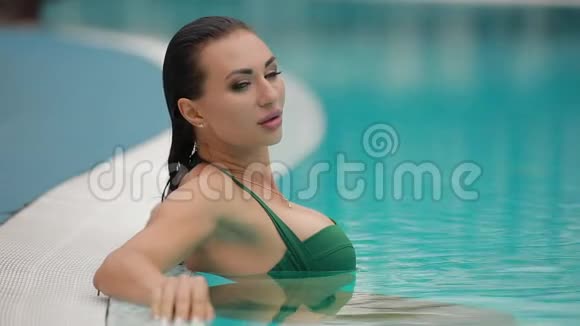 美丽的年轻女子在游泳池里放松视频的预览图