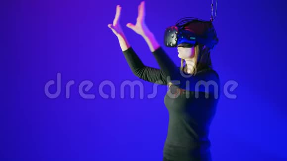 漂亮的年轻女孩使用现代VR眼镜女人触摸一些东西翻转推动增加使用现代虚拟视频的预览图