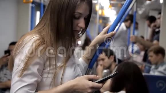 一个漂亮的女孩去地铁握住扶手用电话视频的预览图