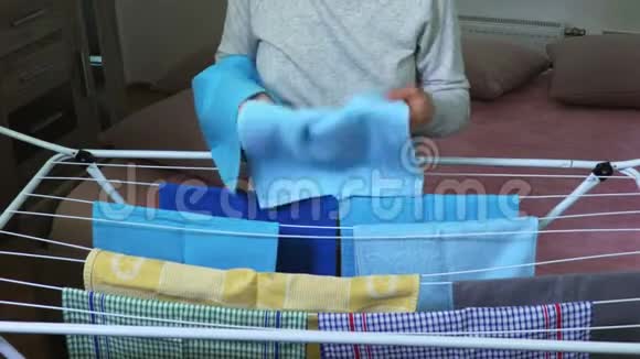 家庭主妇把毛巾挂在烘干机上视频的预览图