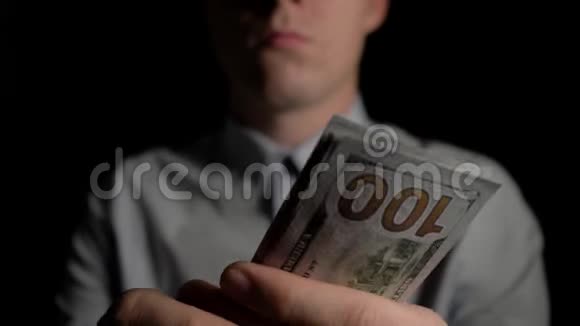 一个在黑暗中计算美元的人那个人数美元男人手里钱意外的胜利这笔费用视频的预览图