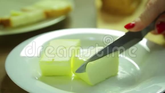 一个女人切了一片黄油在面包上抹上甜饼视频的预览图