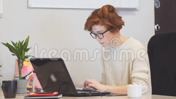 集中精力的女商人戴着眼镜深夜在办公室里用电脑工作视频的预览图