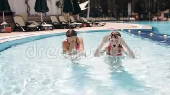 快乐的少女们在泳池里游泳潜水竖起大拇指视频的预览图