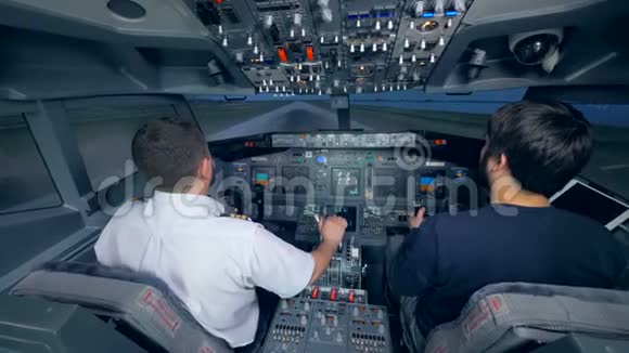 两个人在飞行模拟机上练习着陆视频的预览图