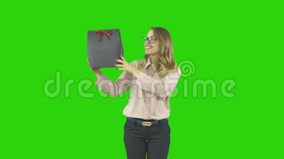 年轻女子手里拿着绿色屏幕上的包裹礼物视频的预览图