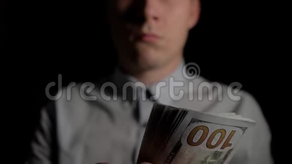一个在黑暗中计算美元的人那个人数美元男人手里钱意外的胜利这笔费用视频的预览图