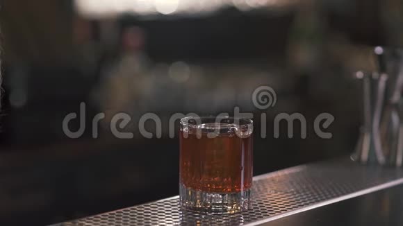 酒吧柜台上摆着一杯威士忌或另一杯加冰的酒精饮料快关门视频的预览图