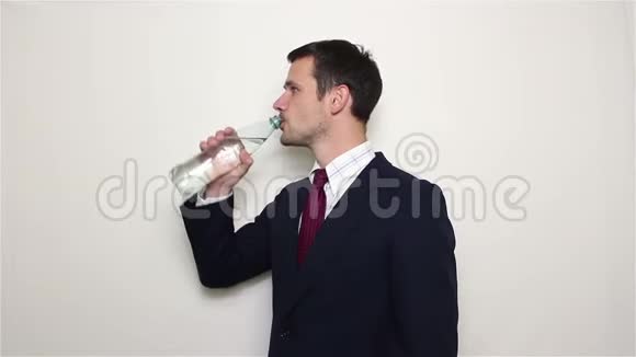 年轻英俊的商人从塑料瓶里喝水视频的预览图