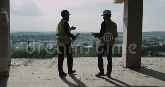 两个年轻的建筑工人穿过大楼进行了讨论视频的预览图