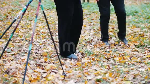 成熟的女人在秋天的公园里做体操双脚视频的预览图