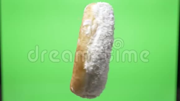 美味的白色甜甜圈椰子片在绿色背景下旋转视频的预览图