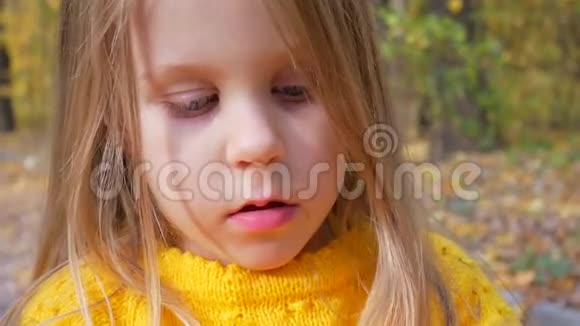 秋天在森林里以黄色树叶为背景的小女孩视频的预览图