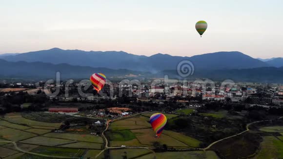 带条纹的热气球飞过地球傍晚的风景和城市几乎没有房子老挝的一条河视频的预览图