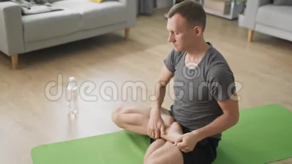 男子在家中进行个人训练放松肌肉和照顾健康视频的预览图