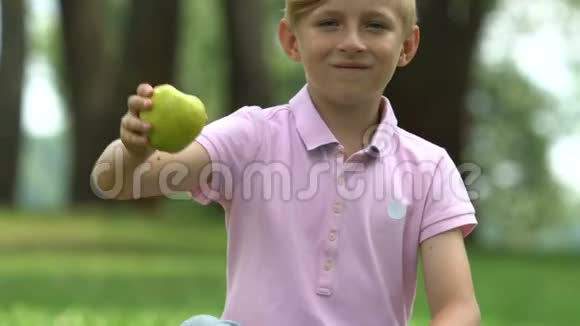 健康的零食快乐的小男孩展示绿色苹果为学童提供营养视频的预览图
