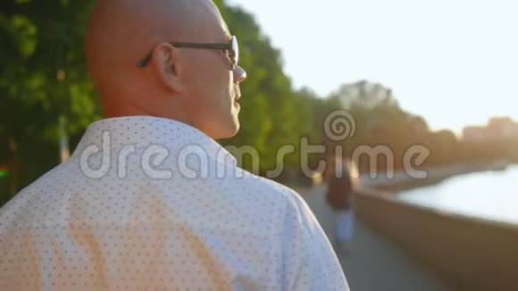 秃头男子在公园散步和向前看的后视镜近距离射击视频的预览图