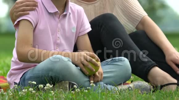 小男孩和有爱心的妈妈抱着苹果家人代表着健康的营养视频的预览图