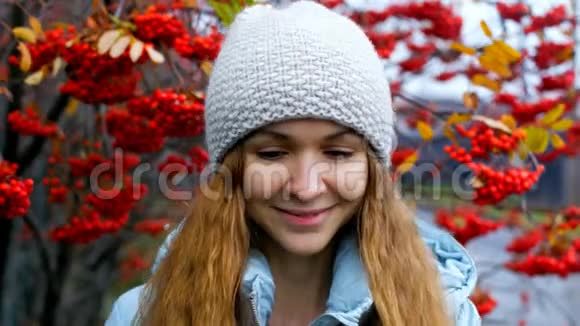 戴帽子的金发女孩在罗旺树旁微笑视频的预览图