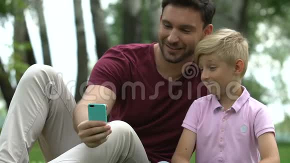 男人和孩子带着自拍抢劫相机家庭休闲和小玩意视频的预览图