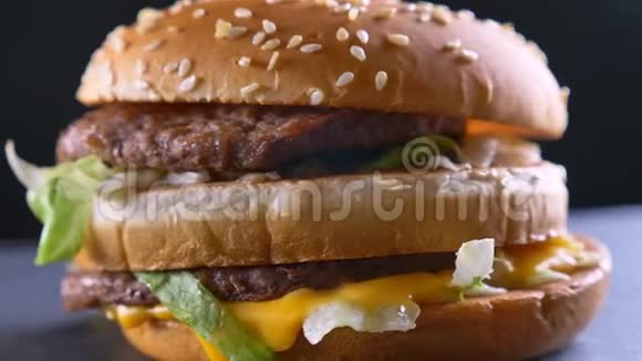 极致的特写镜头美味的双奶酪汉堡两个多汁的馅饼旋转运动视频的预览图
