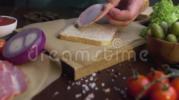 厨师在三明治中加入了烟熏火腿制作了一个由火腿和蔬菜切片制成的三明治视频的预览图