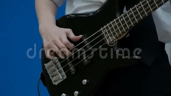 男青少年低音吉他手演奏黑色电吉他特写镜头一个少年的手指在用低音吉他拉弦视频的预览图