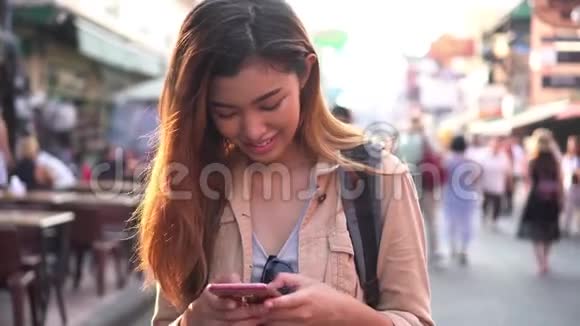 街头市场上使用手机的年轻游客视频的预览图