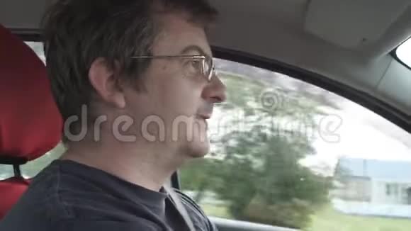 一个戴眼镜的人开车去城里和视频的预览图