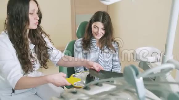一位女牙医告诉她的病人牙套已经对齐了她的牙齿显示了x光一个看牙医女孩视频的预览图