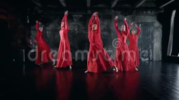 十几岁的女孩在排练室里表演舞蹈穿着红色的裙子跳跃和旋转视频的预览图