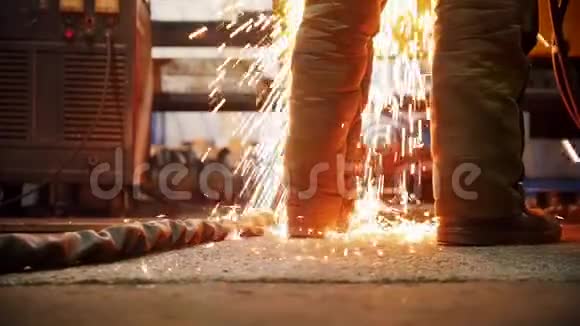建筑工厂一团火在工人脚附近的地板上闪闪发光视频的预览图