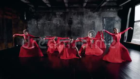 七位迷人的舞女正在排练厅里跳舞她们穿着红色的裙子躺在地上视频的预览图