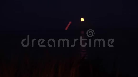 大海背景下燃烧的火焰和在水中反射的月亮的景观视频的预览图